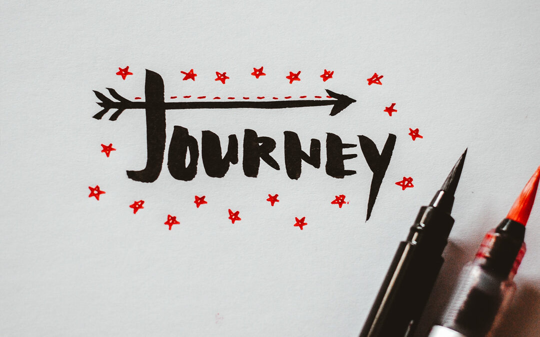 Hand drawn lettering in black and orange ink spelling Journey